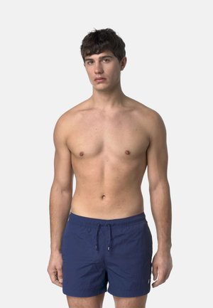 Pantaloni da bagno blu navy in tessuto texturizzato, con vita elasticizzata e cordoncino. Il modello è in piedi con un'espressione neutra e il torso nudo.