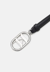 Tirette de clé en forme de carabine en métal argenté avec un design géométrique et une sangle en cuir noir ; présente une gravure "Karl Lagerfeld".
