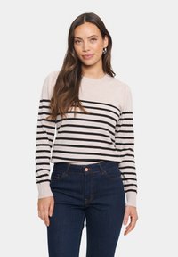 Lätt stickad tröja i beige med svarta horisontella ränder. Har långa ärmar, ribbade muddar och rund halsringning. Pairad med mörka jeans.
