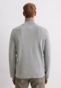 Szary dzianinowy sweter z wysokim kołnierzem, o gładkiej fakturze i luźnym kroju. Widok z tyłu ukazuje subtelne detale szwów oraz długie rękawy.