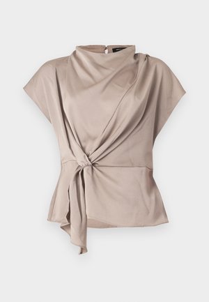 Beige Bluse mit kurzen Ärmeln aus glattem Stoff. Sie hat eine gedrehte Vorderseite und einen asymmetrischen Saum. Der Rücken ist geschlossen und hat einen kleinen Knopf am Hals.