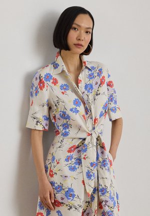 Lilledemustriga särgkleit koorevalgel taustal, millel on siniseid, punaseid ja lillaid lilli. Lühikesed varrukad, krae ja vööümber lips detail. Kerge kangas.