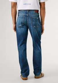 Vaqueros de mezclilla azul con un diseño de pierna recta, que cuentan con un patrón de Union Jack en los bolsillos traseros y una etiqueta de cuero en la cintura.