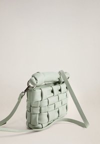 Sac à main en cuir vert menthe tressé avec une poignée nouée, une bandoulière et une forme carrée compacte. Caractérisé par une texture lisse et un éclat subtil.