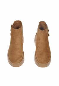 Stivaletti in suede marrone con una texture liscia, punta rotonda e dettaglio con zip laterale. Suola in gomma per stabilità e comfort.