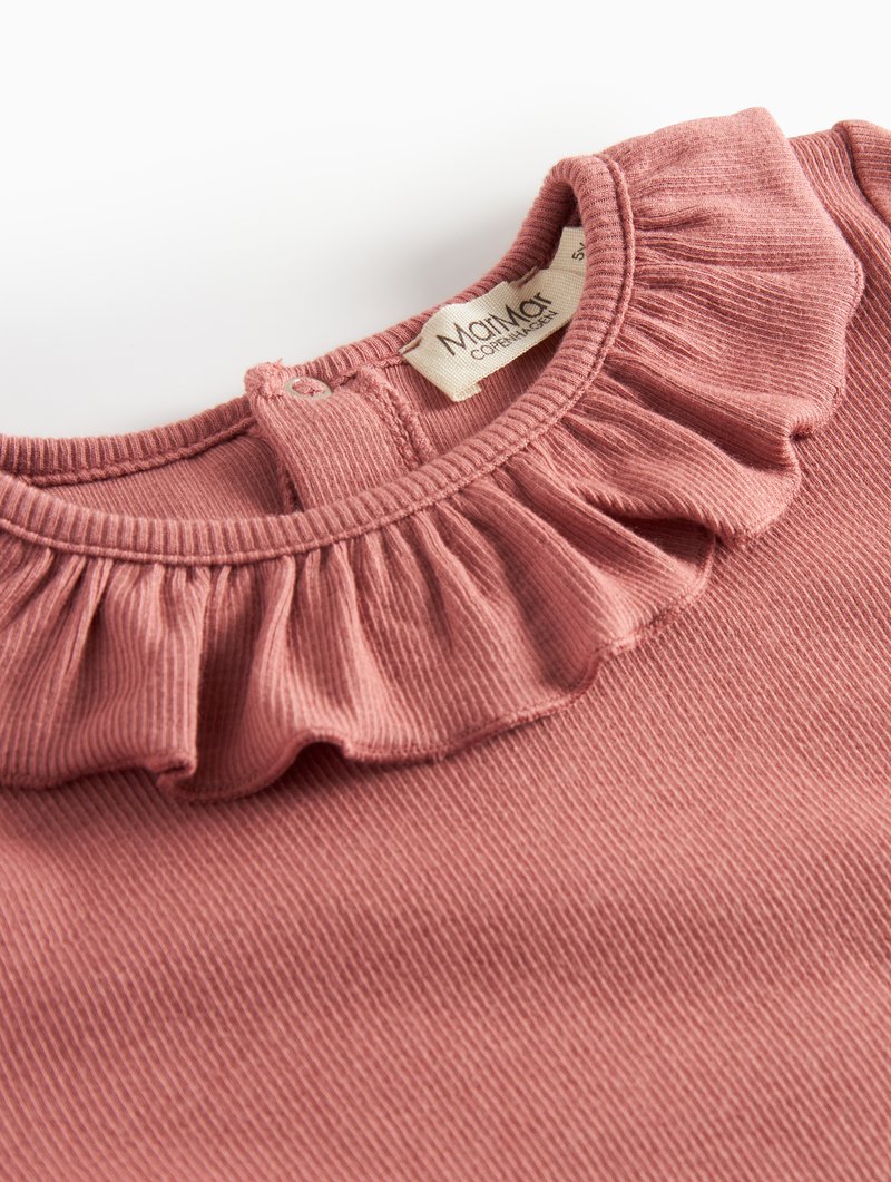 Top de algodão rosa canelado com um colarinho franzido e fecho com botão nas costas. Etiqueta com "Maiami Copenhagen" é visível.