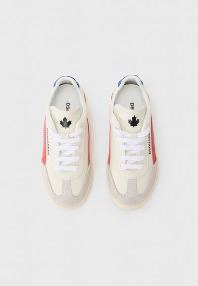 Sneakers z kremową skórzaną cholewką, czerwonymi panelami bocznymi, szarym zamszowym noskiem, białymi sznurówkami i niebieskim akcentem na pięcie. Zawierają czarne logo klonowego liścia.