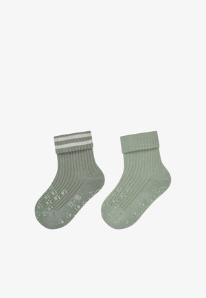 Pair of green ribbed baby socks with fold-over cuffs; one sock has two white stripes and non-slip paw prints on soles.