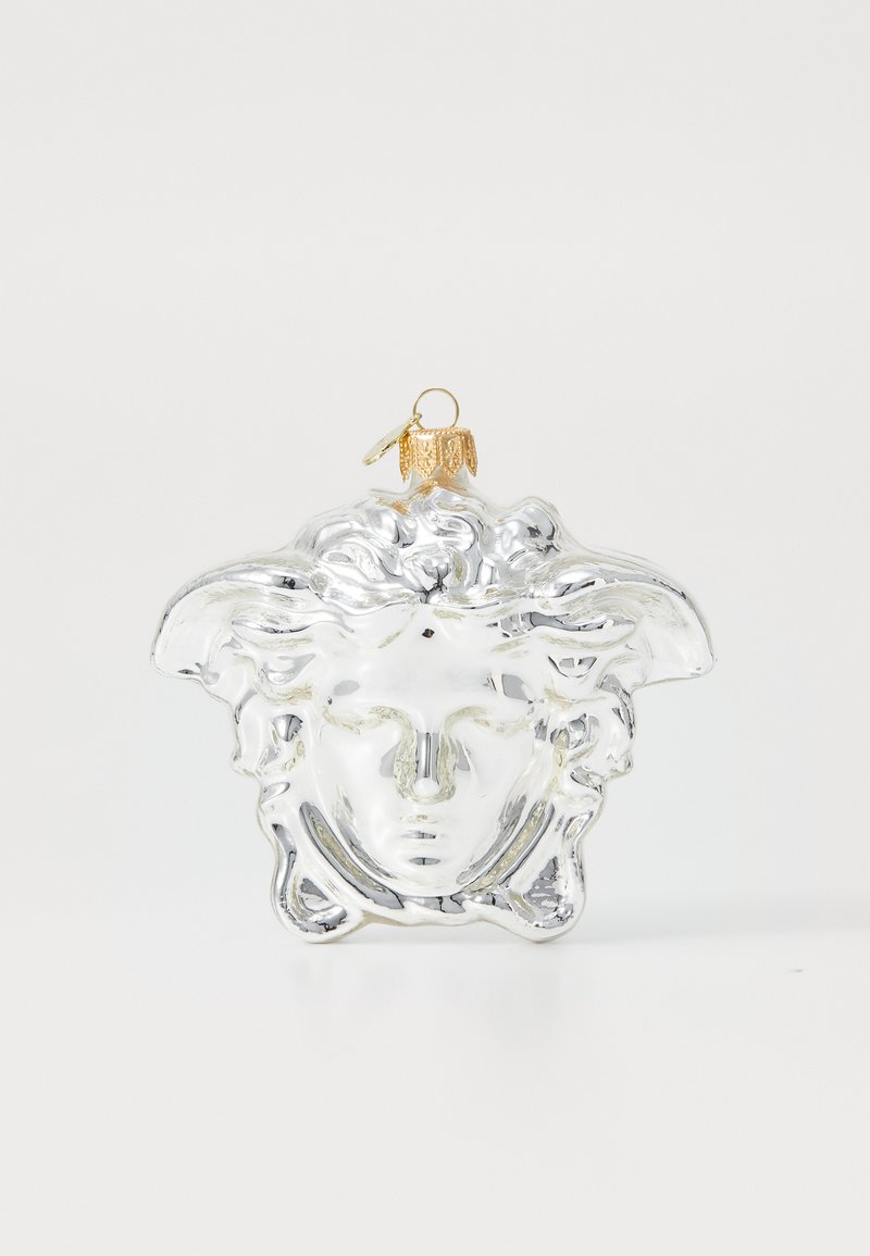 Átlátszó üvegdísz, amely klasszikus maszk formájú, finom részletekkel rendelkezik, és arany fém kupakkal rendelkezik a felfüggesztéshez.