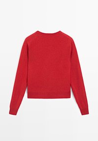 Maglione rosso in lana con maniche lunghe, scollatura rotonda e orlo corto. La texture appare morbida e leggermente pelosa. Nessun motivo o accessorio visibile.