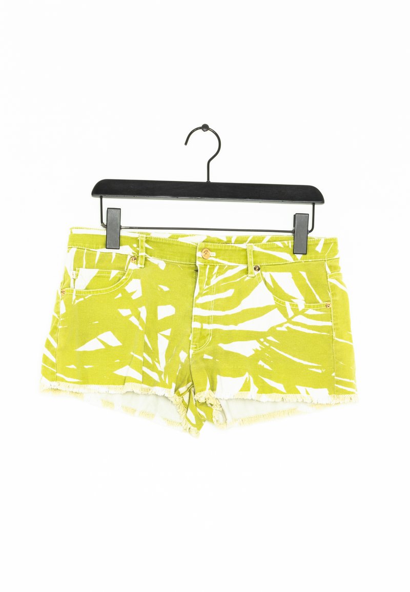 Shorts en denim vert avec un imprimé de feuilles blanches, ourlet effiloché et poches avant. Dotés d'un bouton doré et d'une fermeture éclair, suspendus à un crochet noir.