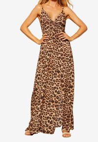 Leopardmönstrad maxiklänning med tunna axelband, V-ringning, rynkad framdel och flödande tyg. Har en lätt, strukturerad design.