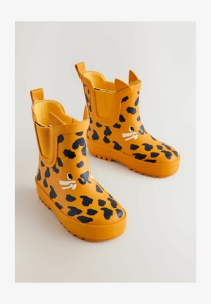 Żółte gumowe kalosze w czarne cętki lamparta, z teksturowanymi podeszwami i ozdobnymi uszkami kota na mankietach. Wyściełane miękkim materiałem.