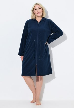 Robe con cappuccio, in blu navy, con zip, realizzato in tessuto morbido. Caratterizzato da maniche lunghe, coulisse e tasche laterali. Lunghezza al ginocchio con taglio dritto.