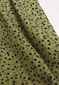 Tessuto verde con stampa floreale nera che presenta fiori delicati e steli, con una texture liscia e una sottile lucentezza.