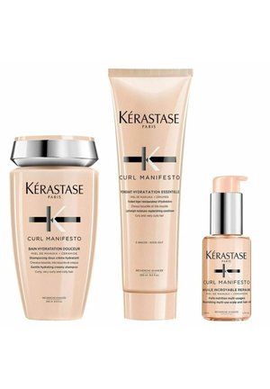 Das Kérastase Curl Manifesto Set enthält ein pinkes Shampoo, einen passenden Conditioner in einer Tube und eine klare Ölflasche mit silbernen Akzenten.