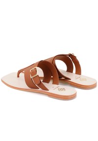 Braune Leder-Sandalen mit zwei gekreuzten Riemen und einem goldenen Schnallenakzent. Flache Sohle mit einer hellbeigen Innensohle und strukturierten Kanten.
