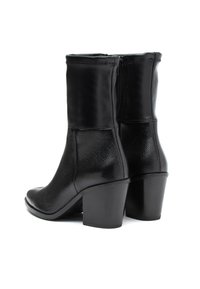 Botas de cuero negras hasta el tobillo con un acabado texturizado, que presentan una puntera redonda, cierre con cremallera y tacones cuadrados.