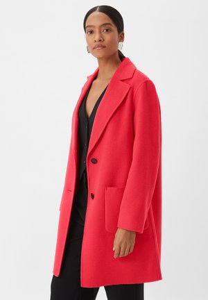 Cappotto rosso di lana con colletto a revers, due tasche anteriori e bottoni neri, caratterizzato da una linea dritta e una consistenza morbida.
