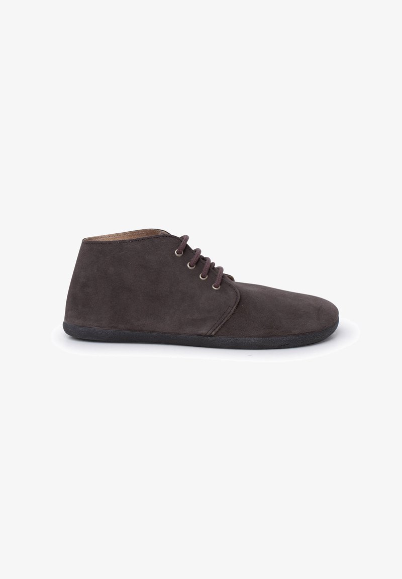 Botas de tobillo de ante marrón con una textura suave, que presentan una puntera redondeada y tres ojales para los cordones, montadas sobre una suela negra flexible.