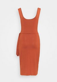 Robe ajustée couleur rouille faite d'un matériau doux. Présente un décolleté en forme de scoop, un design sans manches et un accent noué à la taille.