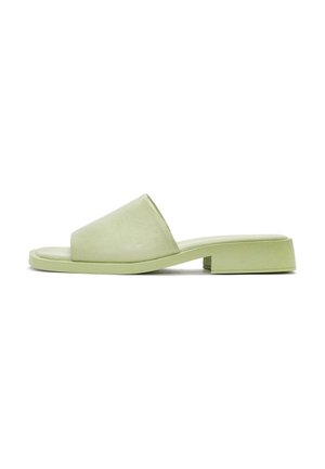 Sandales à glissière vert clair avec une finition lisse, bout ouvert et talon carré. Le design minimaliste met en avant des lignes épurées et une forme contemporaine.