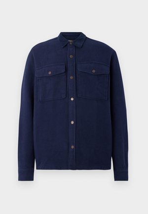 Marineblauwe, button-up shirt gemaakt van textuurstof. Voorzien van twee borstzakken met knoopsluitingen en een kraag. Lange mouwen.