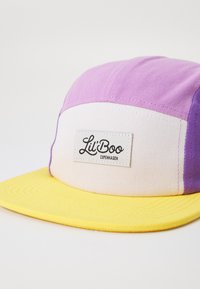 Mehrfarbige Kappe mit einem gelben Schirm, lila und rosa Paneelen und einer weißen Vorderseite mit einem "Lil' Boo Copenhagen"-Label. Aus Baumwolle gefertigt.