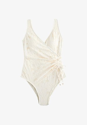 Maillot de bain une pièce en dentelle florale blanche, col en V, design cache-cœur et cordon de serrage latéral réglable noué en nœud.