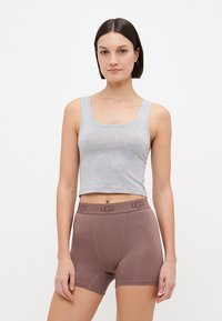 Débardeur gris court associé à un short boxer marron avec une taille logo. Le tissu semble lisse et ajusté.