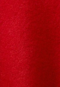 Roter Wollstoff mit einer strukturierten, weichen Oberfläche. Die Webart ist eng, wodurch eine einheitliche Farbe ohne Muster oder sichtbare Nähte zur Geltung kommt.