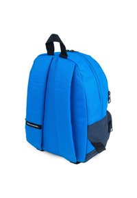 Mochila azul con un tejido texturizado, correas acolchadas y una base azul marino. Cuenta con un asa en la parte superior y un bolsillo lateral con cremallera.