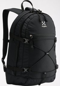 Mochila negra hecha de nylon resistente. Cuenta con correas ajustables, un bolsillo frontal con cremallera y un diseño de cordón elástico en la parte delantera. Base reforzada.