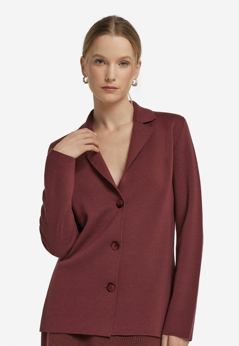 Bordeauxfarbener Blazer, strukturierter Stoff, lange Ärmel, Reverskragen, einreihig mit drei Knöpfen, mit tiefem V-Ausschnitt.