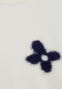 Design cu floare fuzzy cu patru petale de culoare albastru închis, pe un fundal de țesătură albă tricotată.