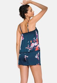 Pyjamaset met bloemenpatroon in donker teal, bestaande uit een mouwloze top met smockdetails en bijpassende shorts met een relaxte pasvorm.