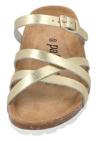 Sandalo color oro con fibbie in pelle incrociate, soletta in sughero e chiusura a fibbia. Suola piatta con una finitura naturale e strutturata.