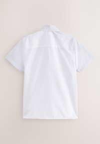 Chemise blanche unie à manches courtes avec col, vue de dos sur un fond neutre.