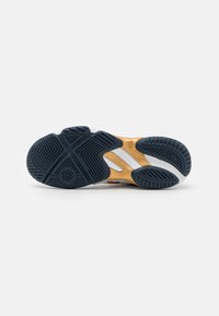 Semelle de sneaker en caoutchouc noir et bleu, avec des accents dorés, un motif de semelle texturé et des sections blanches ; design ergonomique pour traction et stabilité.