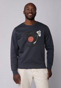 Marineblaues Sweatshirt mit einem Grafikdesign von einer Schallplatte mit rotem Mittelpunkt, gestaltet mit einem Plattenspielerarm; weicher Stoff, Rundhals und gerippte Bündchen.