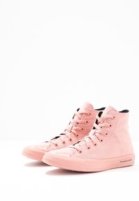Wysokie trampki w miękkim różowym płótnie z czarnym wykończeniem, z gumowym noskiem, sznurowaniem z przodu i teksturowaną podeszwą.