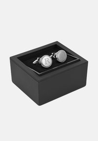 Srebrne spinki do mankietów z wygrawerowanym "R" w okrągłym wzorze. Prezentowane w czarnym pudełku z miękkim czarnym wnętrzem.