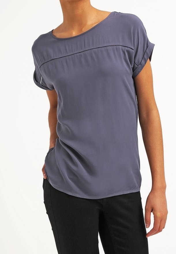 Haut à manches courtes en tissu violet clair. Il présente un col arrondi, des manches retroussées et un détail de couture horizontale sur la poitrine.