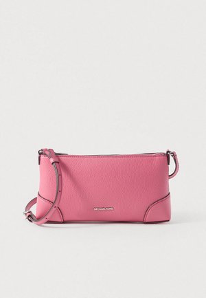 Sac bandoulière en cuir rose texturé avec sangle ajustable et logo Michael Kors argenté à l'avant sur fond uni.