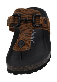 Brune ruskindsandal med zebra-stribe mønster, der har en sort spænde, thong-design og en tekstureret sort fodseng med en korksål.
