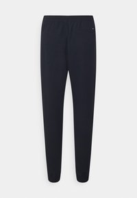 Marineblaue Baumwoll-Jogginghosen mit elastischem Bund, schmal zulaufenden Beinen und gerippten Bündchen. Verfügt über eine kleine Gesäßtasche mit minimalem Branding.
