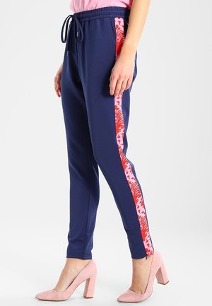 Joggers marinos con paneles laterales de estampado rosa, cinturilla elástica y cordón ajustable, diseño de pierna ajustada, fabricados en tejido suave y elástico.