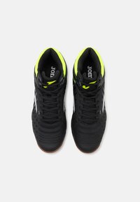 Zapatillas deportivas negras con una parte superior texturizada, acentos en verde amarillo en el collar y una suela de goma. Presenta un logotipo de marca blanco en contraste.