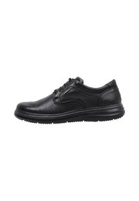 Zapato negro de cuero para hombre, tipo casual, con cordones, superficie texturizada y suela gruesa y estriada, mostrado de lado sobre un fondo blanco.