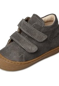 Chaussure pour bébé en suède gris avec deux bandes velcro, bout arrondi et semelle en caoutchouc avec un motif de grip texturé.